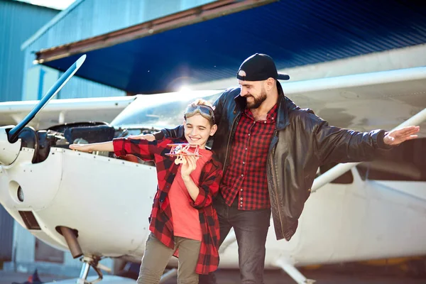 dad and son playing, pretending airplanes, standing with hands apart like wings