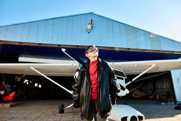 Malý chlapec ve velké pilotní bundě hledí na oblohu a zdálo se, že letí pryč — Stock fotografie