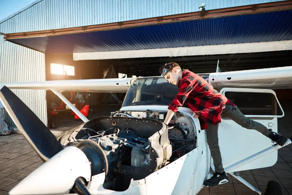 Vista del avión ligero de la hélice con el gabinete abierto del motor, muchacho adolescente que está parado cerca — Foto de Stock