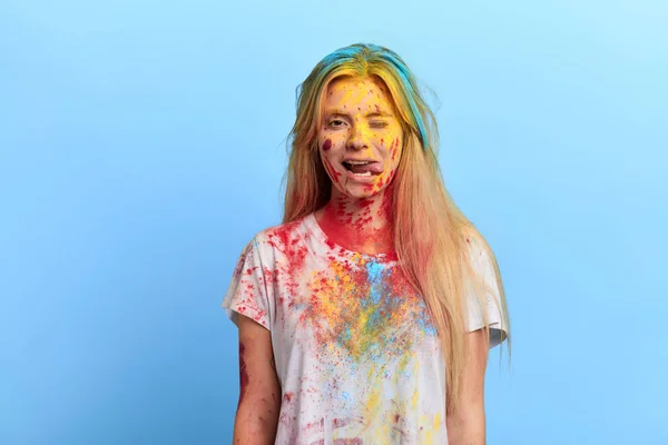 Mädchen mit schmutziger Kleidung und Gesicht, das ihre Zunge verbindet und in die Kamera zwinkert — Stockfoto