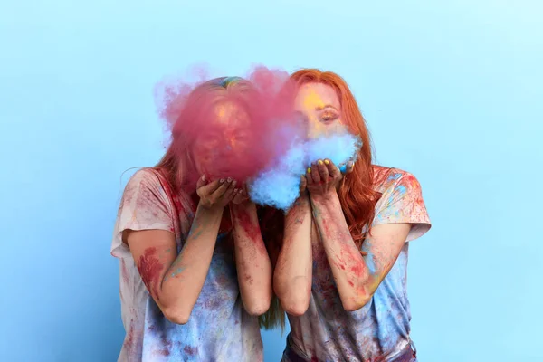 Happy funny girls blowing colourful powder — Stock Photo, Image