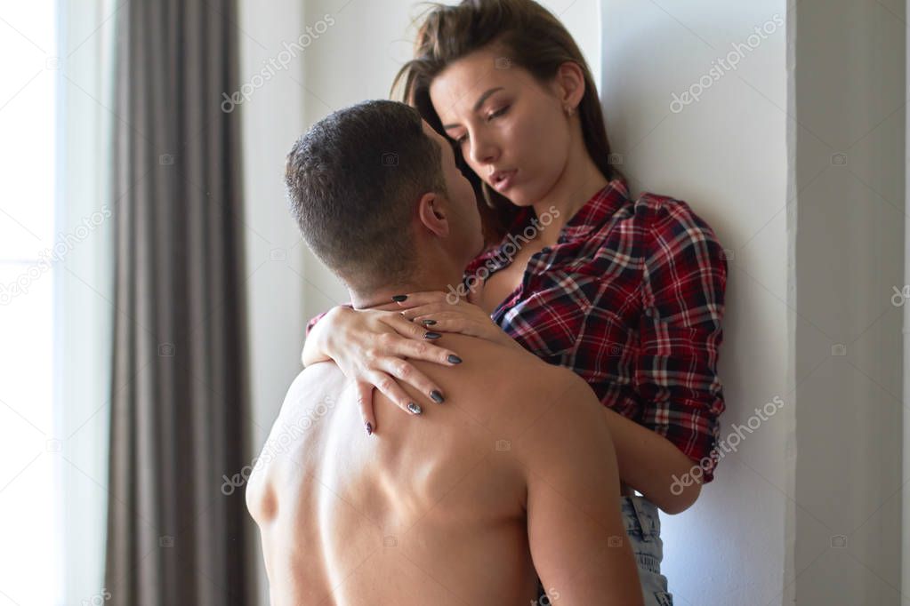 young sexy black-haired woman in shirt embracing her boyfriend