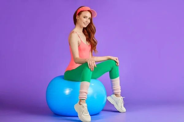 Здоровый тонкий имбирь девушка сидит расслабленной на фитнес-мяч, руки на колени — стоковое фото
