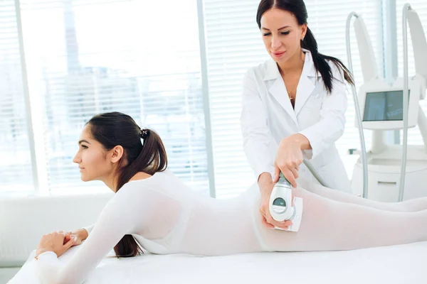 Bella donna bruna che ottiene un massaggio GPL per il sollevamento del corpo in tuta GPL — Foto Stock