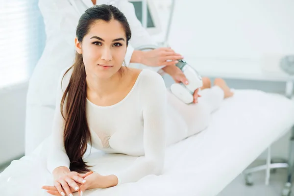 Morena feliz mujer disfrutando de GLP masaje en el salón de belleza . — Foto de Stock