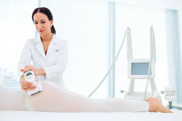 Bruna medico cosmetologico che esegue il massaggio GPL presso il centro di medicina estetica . — Foto Stock