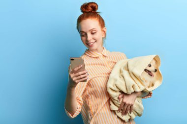 mutlu neşeli zencefil kız onun en sevdiği evcil hayvan tutarak ve bir fotoğraf çekmek
