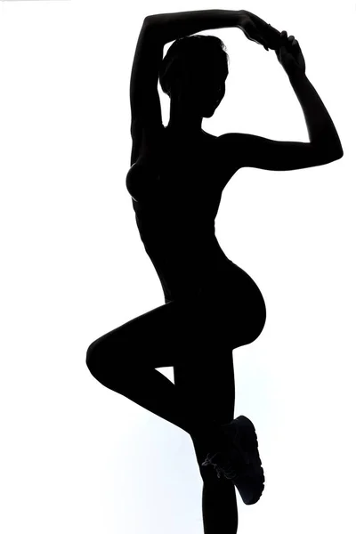 Sportliches Mädchen mit erhobenen Armen, auf einem Bein stehend — Stockfoto