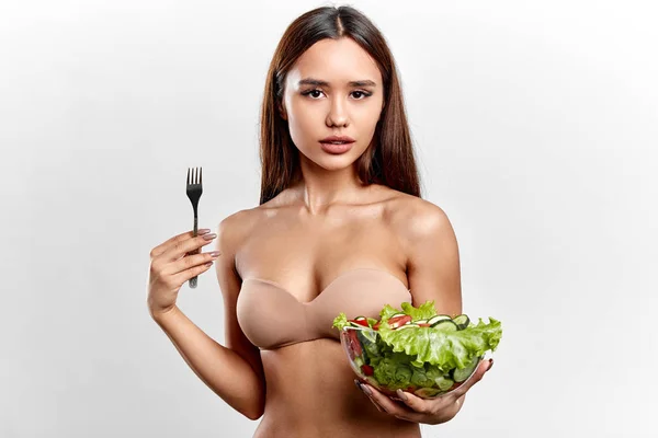 Asiatische attraktive Mädchen mit vollen Lippen hält eine Gabel und eine Schüssel mit Sommersalat — Stockfoto