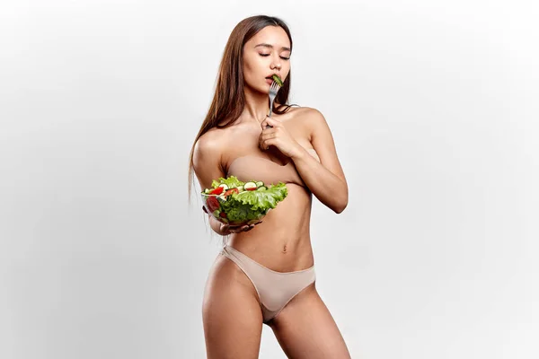 Erotisk flicka med en gurka i munnen poserar på kameran — Stockfoto