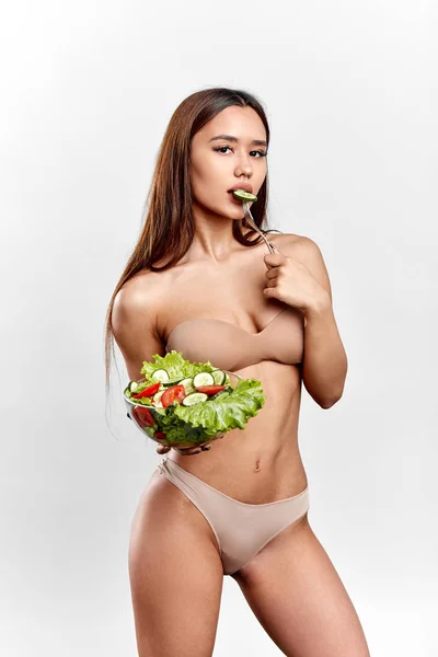 La mujer está interesada en comer verduras. chica tratando de llevar un estilo de vida saludable —  Fotos de Stock