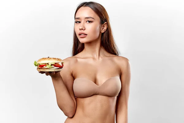 섹시한 여자는 그녀의 남자 친구를 위해 맛있는 햄버거를 준비했다. — 스톡 사진