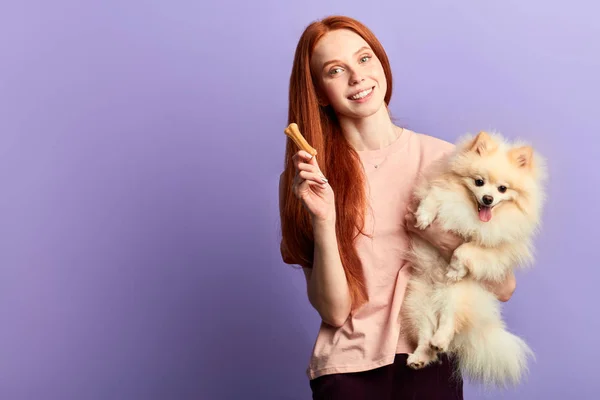 Sonriente hermosa chica tratar su perro con galletas — Foto de Stock