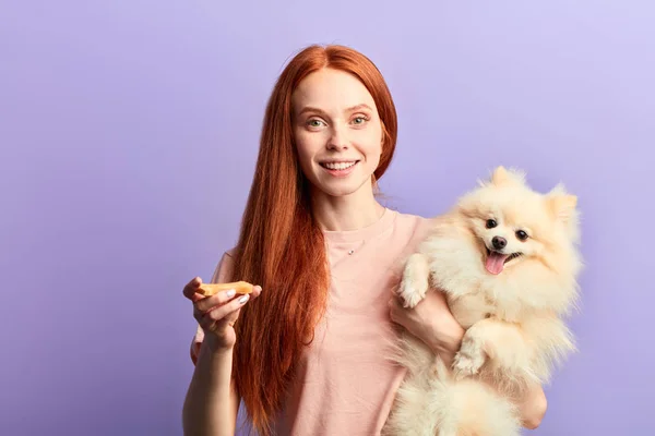 Bien parecido alegre chica con largo pelo rojo toma el cuidado de su mascota — Foto de Stock