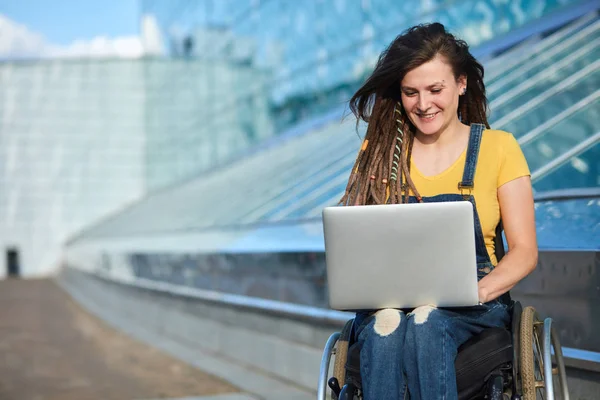 Glücklich süße Geschäftsfrau im Rollstuhl, die mit einem Laptop arbeitet — Stockfoto