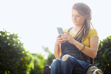 gardern dinlenirken onu akıllı telefon kullanarak çekici hipster kız