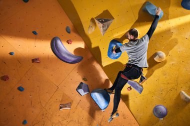 Fiziksel engelli adam bouldering spor salonunda zor kaya duvarında sıkışmış