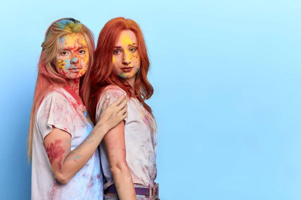 Två systrar med smutsiga ansikten och stänger stående över Blå bakgrund — Stockfoto