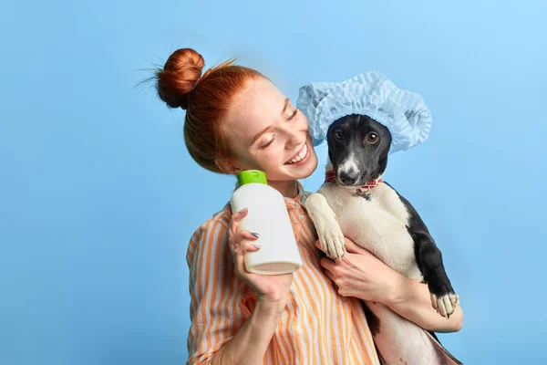 Імбир дівчина насолоджується пранням собаки з піною і водою . — стокове фото