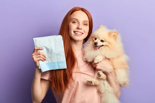 Red-haired pretty positive girl controlling pissing process of her pet — Stock Photo, Image