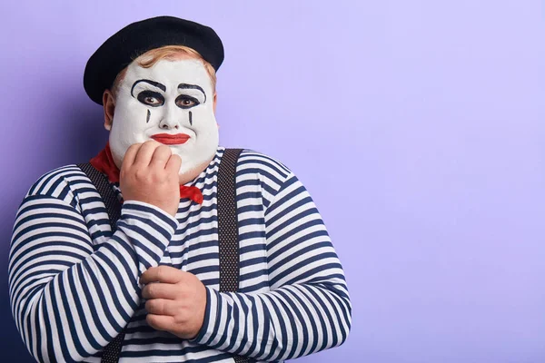 sad unhapy depressed clown touching his chin, crying