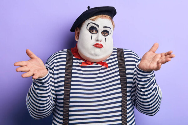 I dont know. puzzled man with raised arm expresses his disinterest