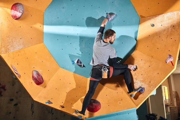 İnce fiziksel engelli sporcu yapay kaya duvarında yukarı hareket