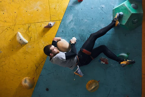 Pedregulho fisicamente motivado com barba pendurada na parede de escalada — Fotografia de Stock