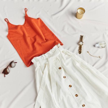 şık beyaz etek, kırmızı üst, yatakta yatan aksesuarlar