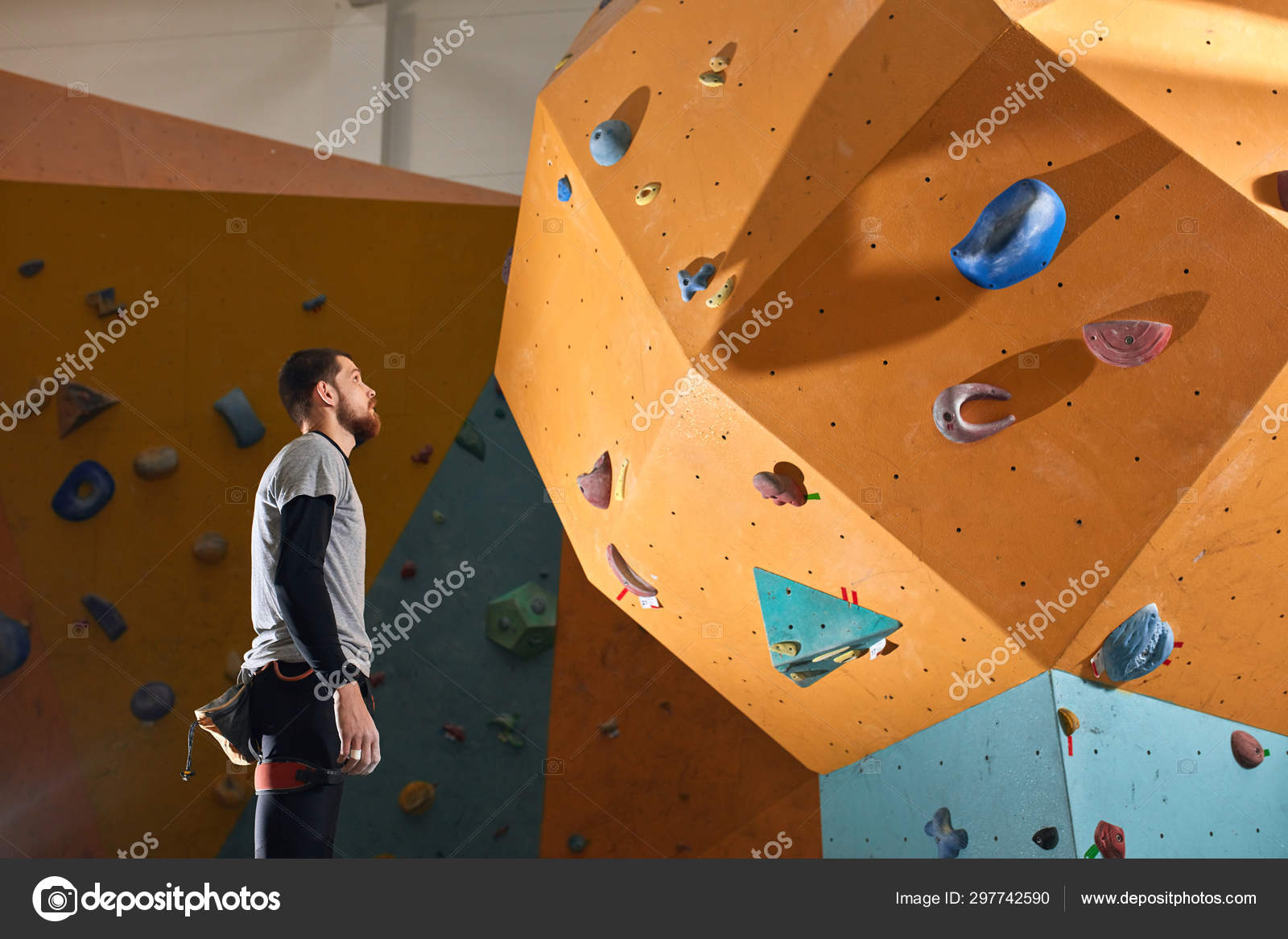 Active physically challenged boulderer stands near difficult climbing