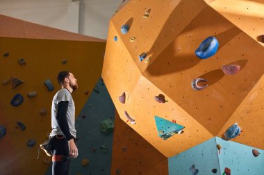 Aktif fiziksel engelli boulderer zor tırmanma duvarı yakınında duruyor