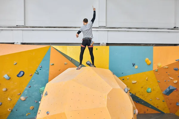 Manlig modell med fysiskt funktionshinder stående på toppen av väggen i klättrings gym — Stockfoto