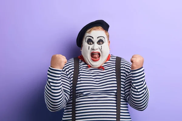 cheerful funny plump mime artist gesturing joy with his hands