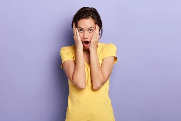 Emotioneel meisje raakt haar wangen, spreekt verbazing, heeft mond wijd geopend — Stockfoto