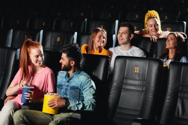 genç adam ve kadın gülerek, film izlerken flört