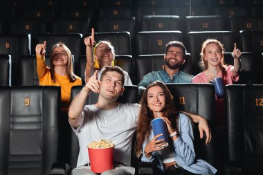 patlamış mısır film izlerken genç gülümseyen neşeli arkadaşlar