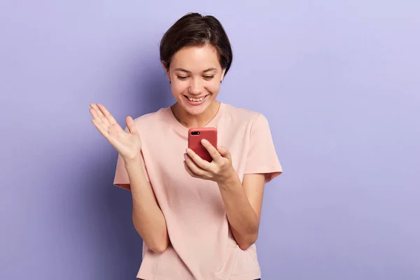 Cheerful positive charming girl texting on the smarphone — стоковое фото