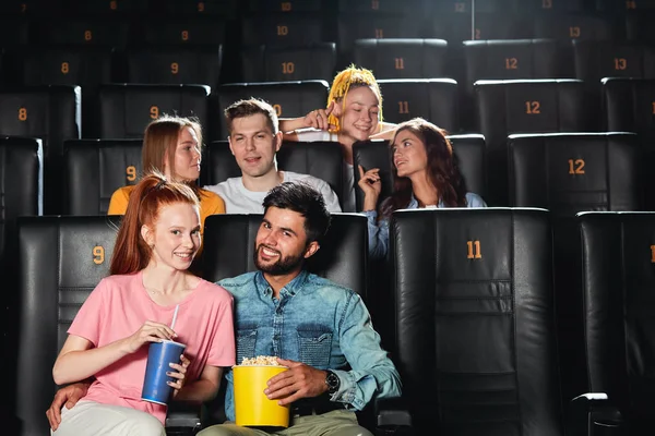 Pareja de raza mixta en ropa elegante sentado en el cine y mirando a la cámara — Foto de Stock