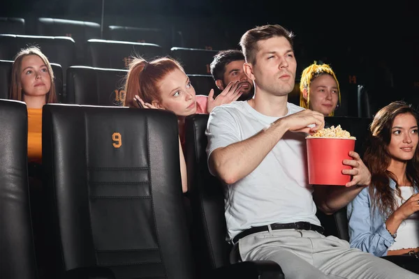 El tipo en el cine molestando a la chica pelirroja para ver una película — Foto de Stock