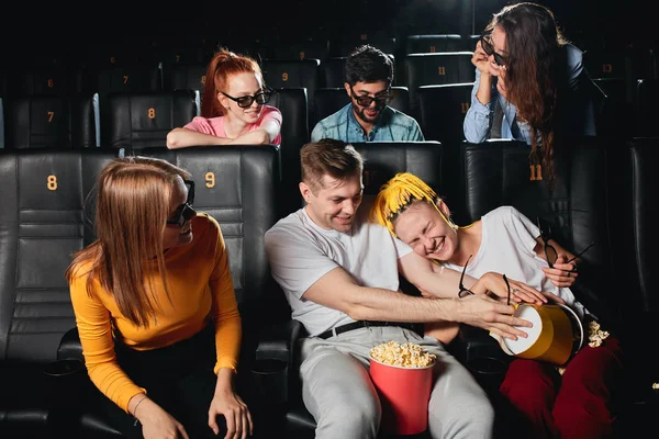 Grappige man en vrouw vechten met popcorn tijdens de sessie in de bioscoop — Stockfoto