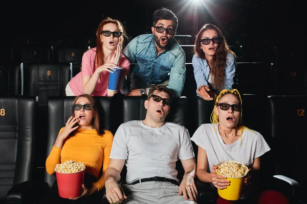 Portret van een verbaakte groep jonge mensen die op het scherm staren — Stockfoto