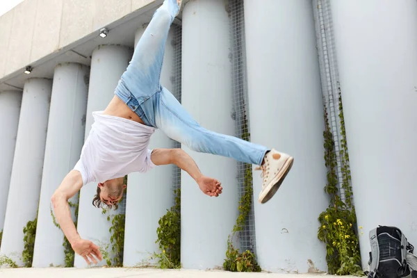 Bailarina haciendo un movimiento, hombre cayendo mientras realiza una voltereta —  Fotos de Stock