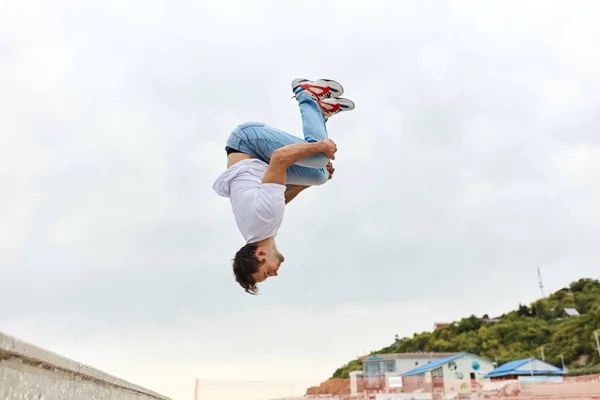 屋外で宙返りを投げる若い男 — ストック写真