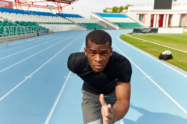 Confident serious motivated man running on a stadium track, fast speed motion — Stock Photo, Image