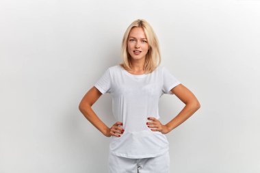 çekici genç kadın rahat kalçalarında elleri ile poz giyinmiş