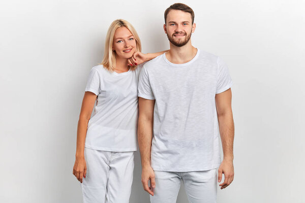 blonde girl leaning on her boyfriends shouder and posing to the camera