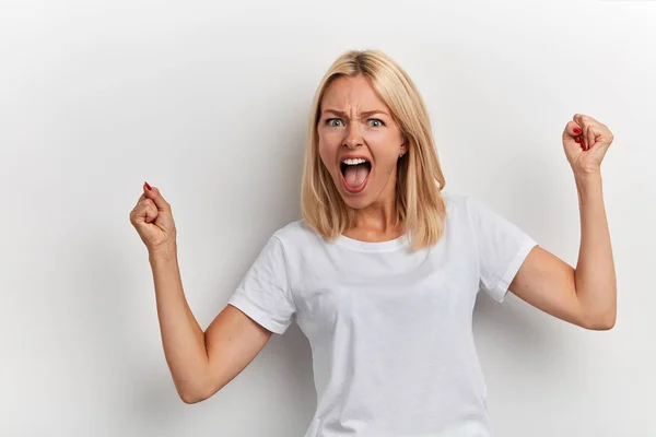 Retrato de una mujer alegre en una elegante camiseta blanca celebrando su éxito —  Fotos de Stock