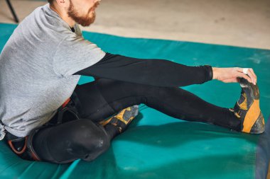 Tanınmayan boulderer eğitim tırmanma önce germe egzersizleri yapıyor