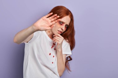 kendini korumaya çalışan yaralı kız, avuç içi ile yüzünü kapatarak