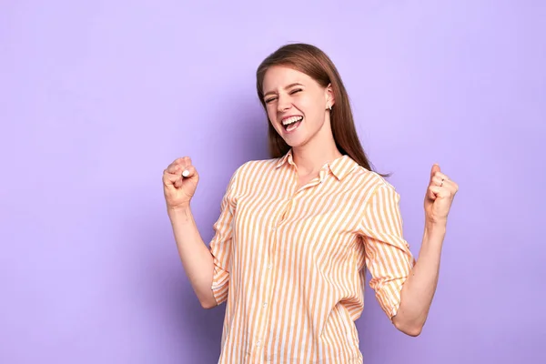 Emotionell ung kvinnlig student, håller händerna knutna i nävar, oerhört glad — Stockfoto